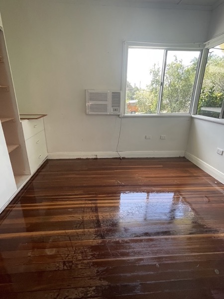 Polished timber floorboards running through an empty room to a doorway