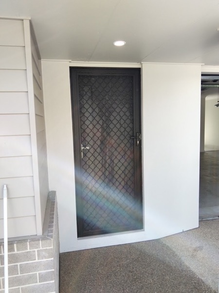 An open front door looking into a carpeted entry and hallway